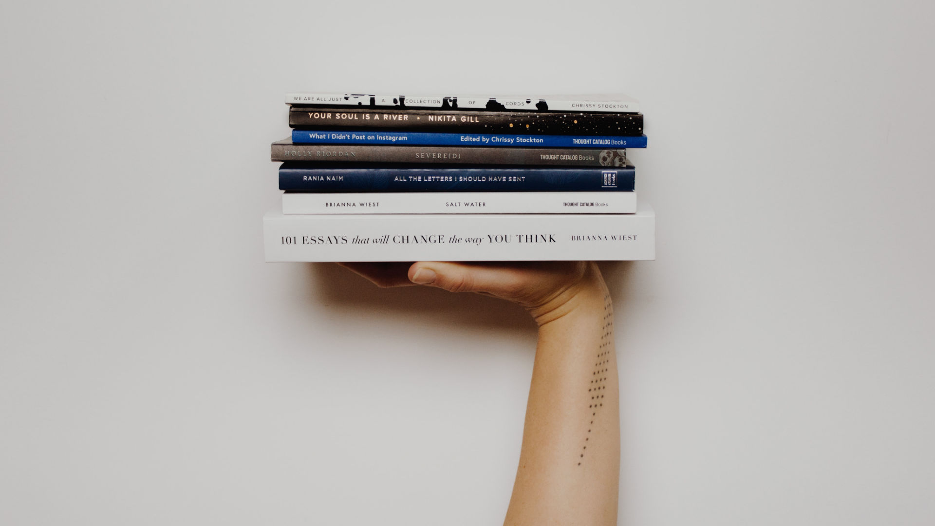 Bücherstapel auf einer Hand – unsere Spartipps für Leseratten.